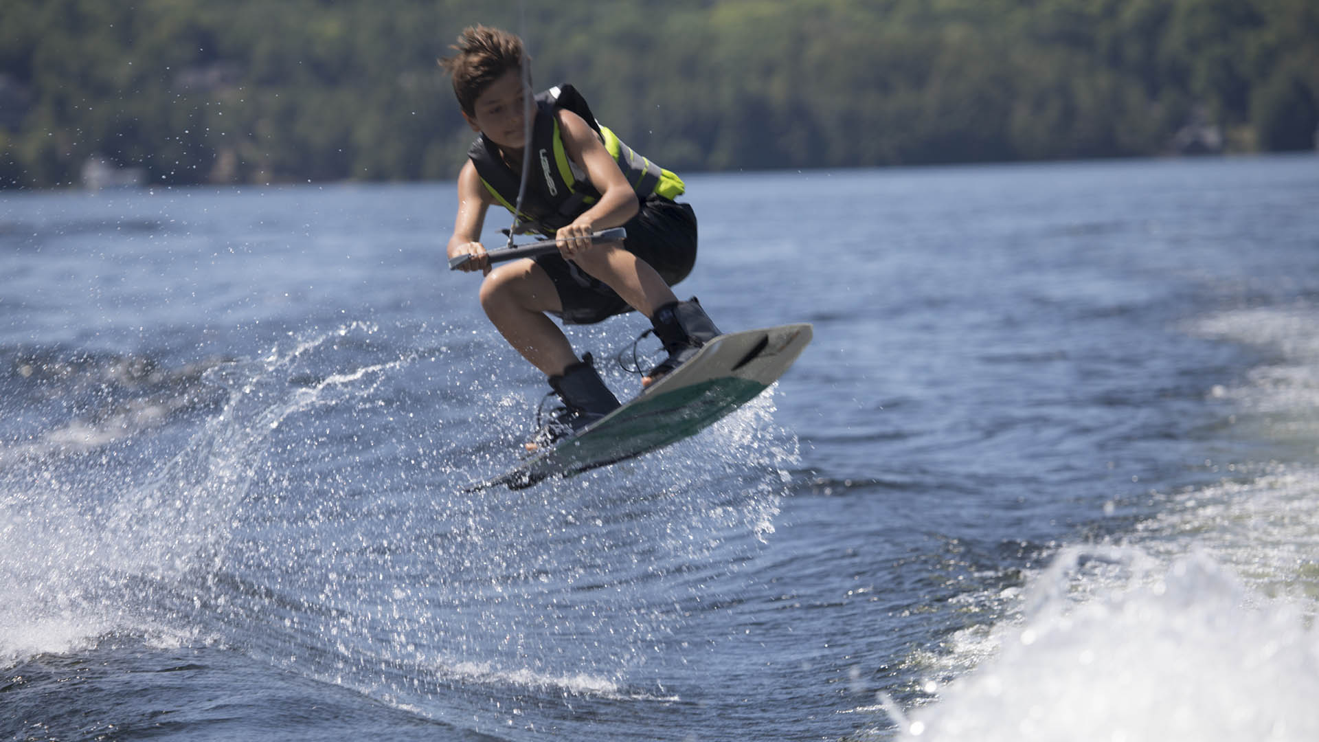 A Muskoka Woods camper wakeboards at overnight summer camp